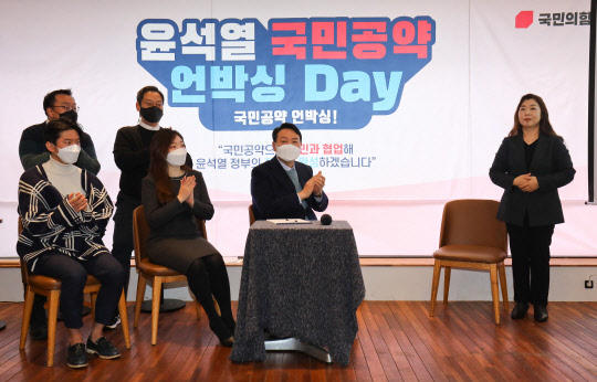 윤석열 국민의힘 대선후보가 23일 서울 여의도 한 카페에서 열린 '국민공약 언박싱 데이' 행사에서 '윤석열 공약위키' 홈페이지를 통해 제안받은 공약 4가지 발표를 지켜보고 있다.[국회사진기자단·연합뉴스]